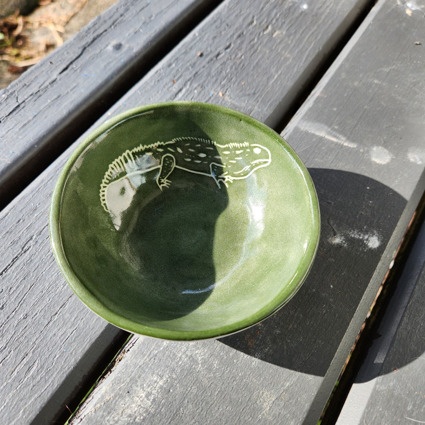Green ceramic bowl with a white Tuatara design